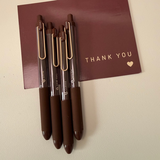 Set of pens with a 'Thank You' card on a beige background